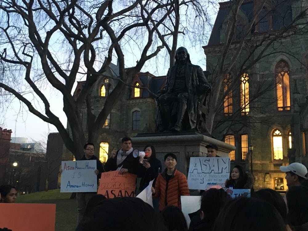 Six student protestors stand in front of the Ben Franklin statue on College Green with other protestors demanding more resources for the ASAM program. Photo courtesy of The Daily Pennsylvanian