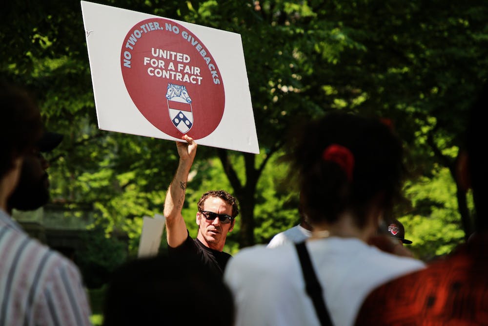 Many University-affiliated staff members have said that Penn has promoted union-busting strategies to their advantage. Photo shows white, male protestor with a sign that demands a fair contract for custodial staff and housekeeping workers. Photo courtesy of The Daily Pennsylvanian